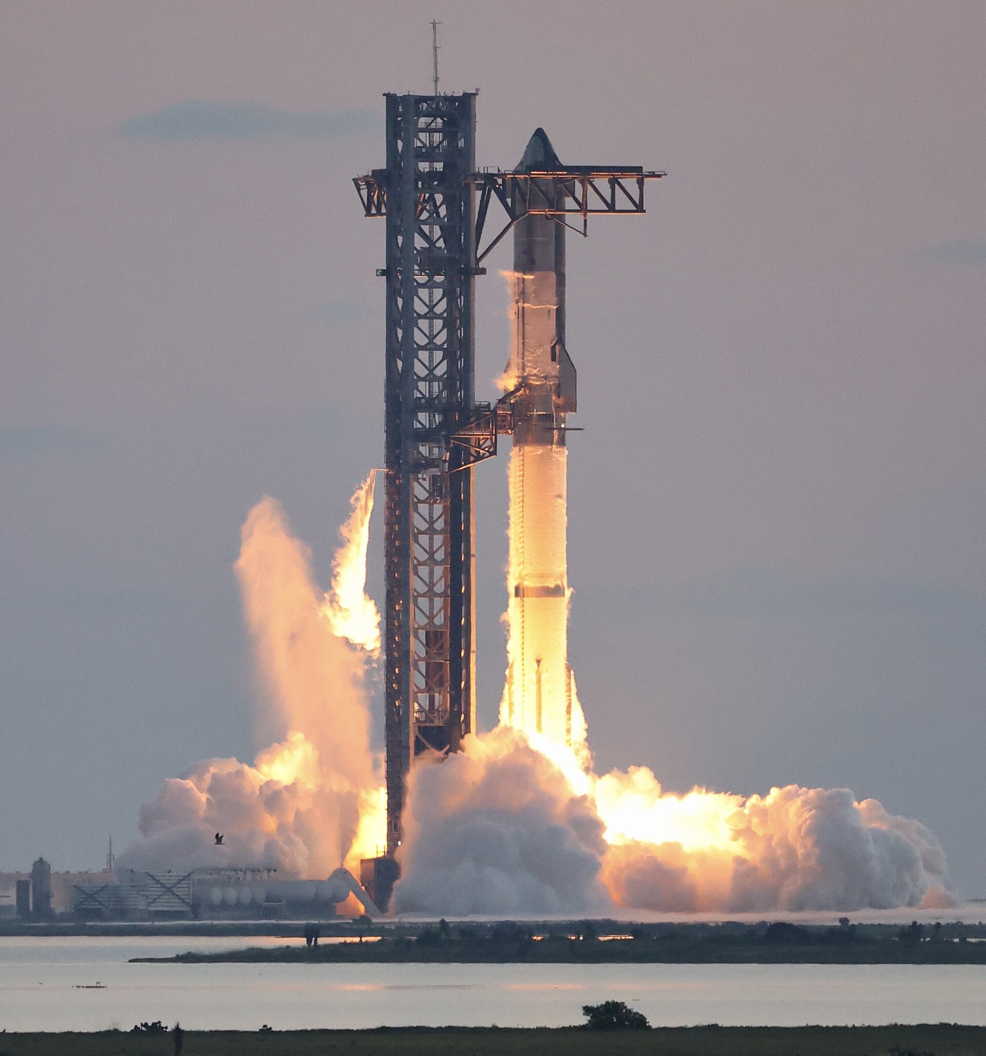 A Super Heavy booster's 33 Raptor engines ignite at Starbase, Texas, at the start of Starship's fifth test flight in October 2024.