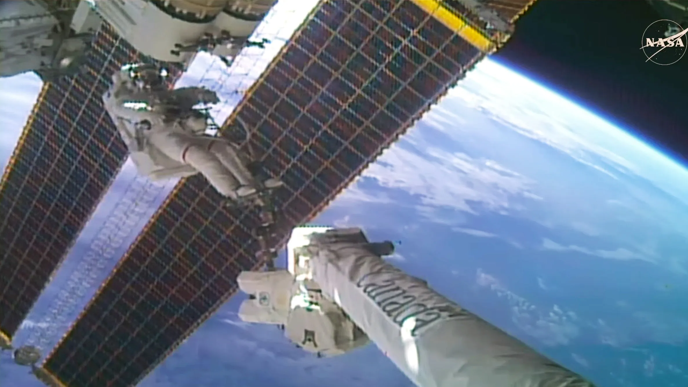 NASA astronaut Anil Menon rides Canadarm2 while beginning installation of a roll-out solar array on the International Space Station's port truss duri…